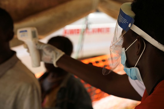 Uganda: man having his temperature checked at a border crossing point