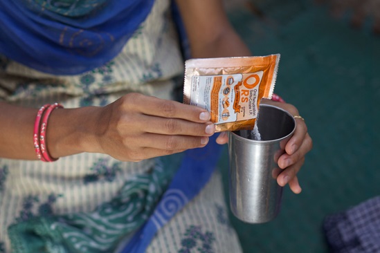 A woman mixes a glass of oral rehydration salts