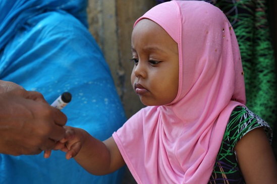 Somalia: young girl has her fingernail marked to show that she has received the oral polio vaccine