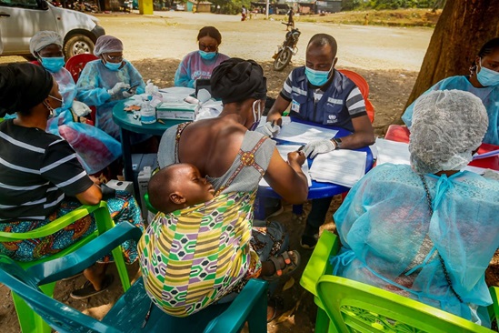 Guinea 2021: a nurse and a WHO staff member help members of the community of Gouéké read through consent forms prior to receiving the rVSV-ZEBOV Ebola vaccine