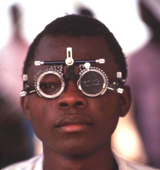 Cameroon 1992: a teenage boy undergoing an eye test at a field clinic