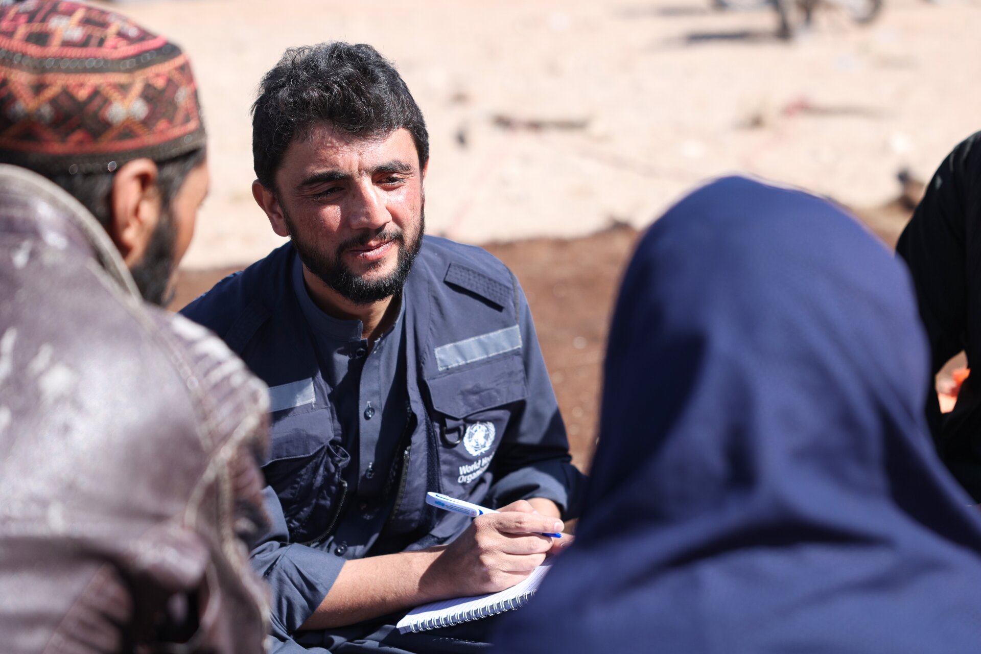 WHO Staff Herat Earthquake 2023 A WHO Officer take notes as he speaks to people.
