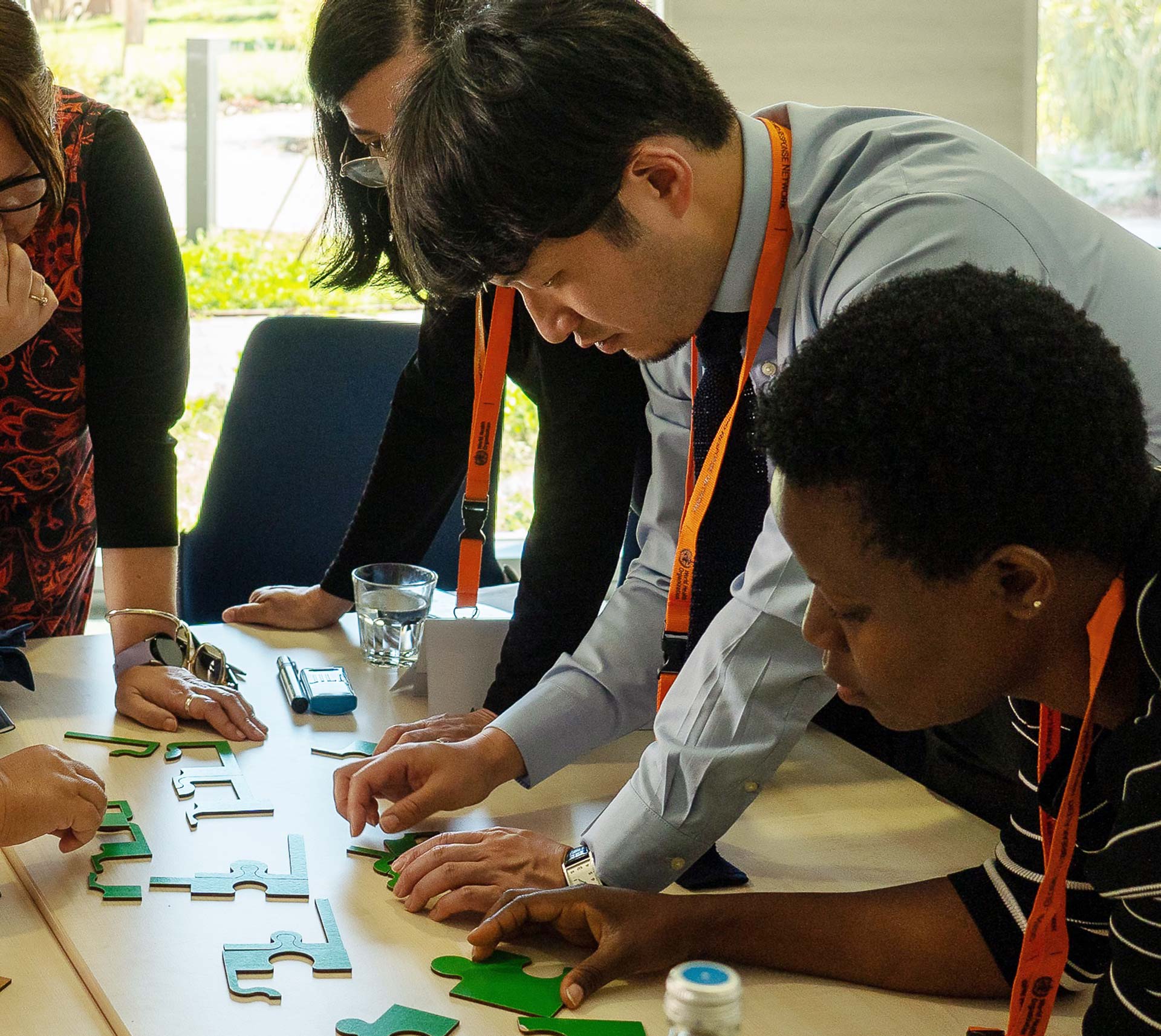 People attending a hands-on interactive workshop, playing with jigsaw pieces at a table
